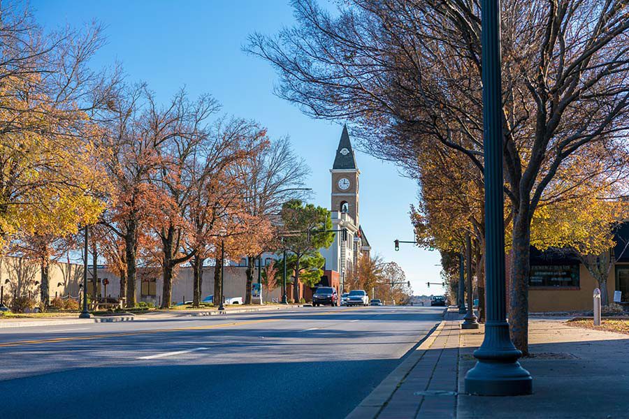 Contact - View of a Main Street with a Church and Businesses in a Small Town with Colorful Fall Foliage